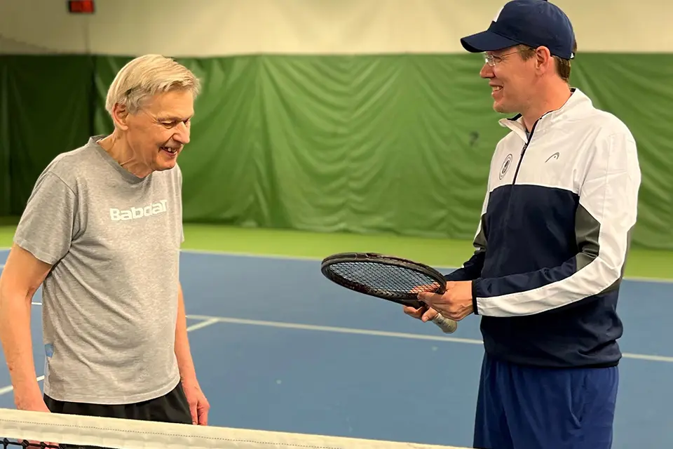 Frej Johnson, klubbchef i Spårvägens Tennisklubb, med en av sina klienter