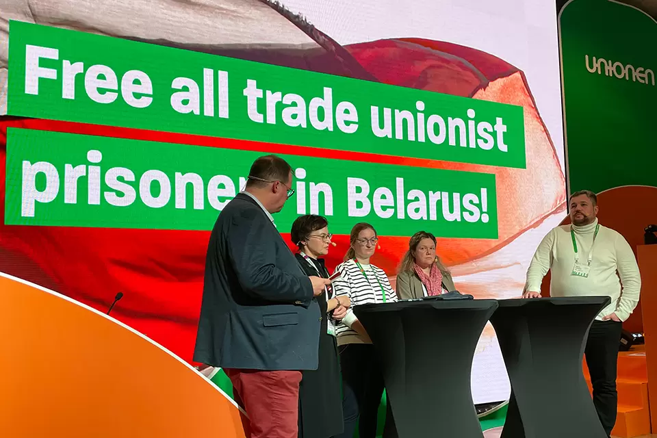 Foto på talare på scen medtexten Free all trade unionist prisoners in Belarus i bakgrunden
