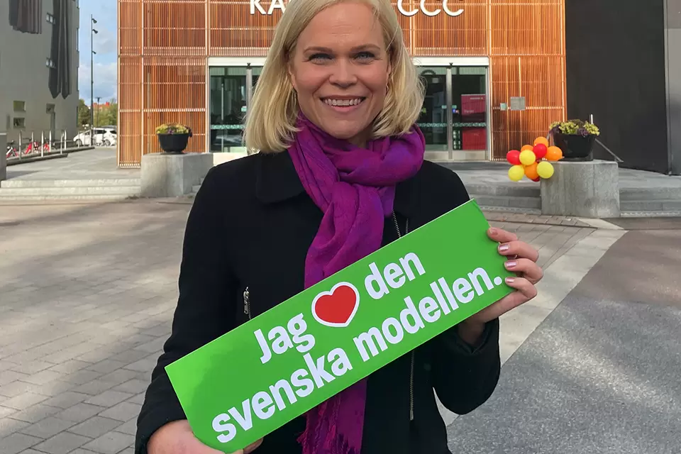 Paulina Brandberg med en skylt med texten Jag älskar svenska modellen