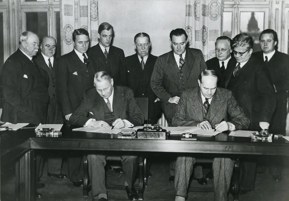 Foto på August Lindberg, ordförande i  LO, och Gustav Söderholm, VD för SAF, skriver under Saltsjöbadsavtalet 1938. 