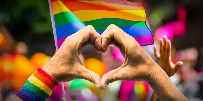 Händer gör hjärtform i Pride-tåg
